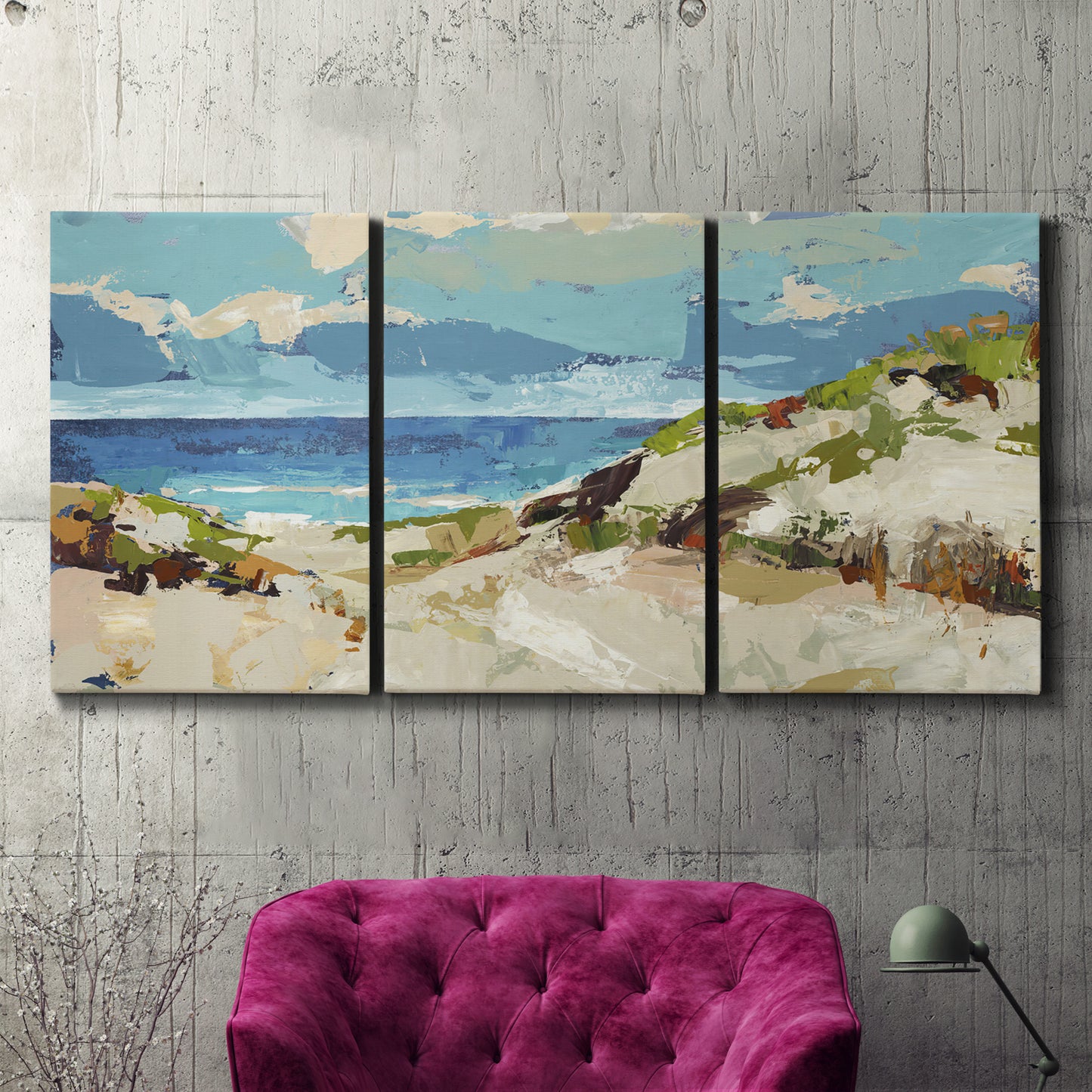 Three-panel canvas wall art featuring sand dunes beside open water, displayed in a living room above a suede accent chair.