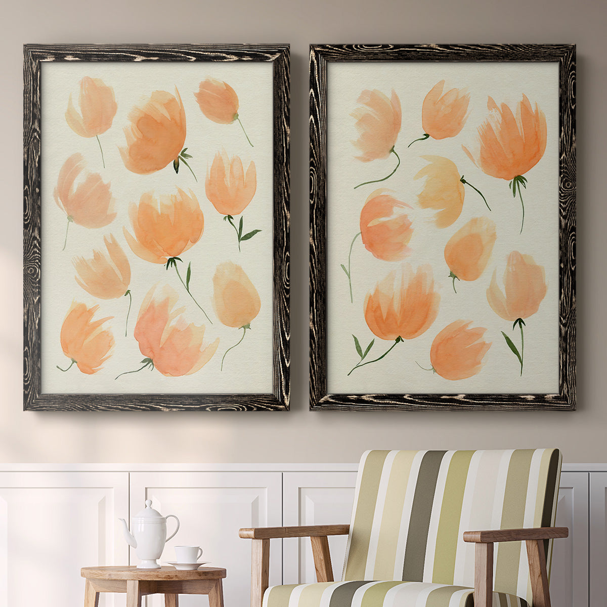 Set of two black barnwood framed canvas prints depicting two airy watercolor floral paintings featuring loose peach-orange tulip-like blossoms above a sideboard in a cozy sitting room.