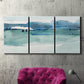 Three-panel canvas wall art featuring minimalist ultramarine abstract vista, displayed in a living room above a suede accent chair.