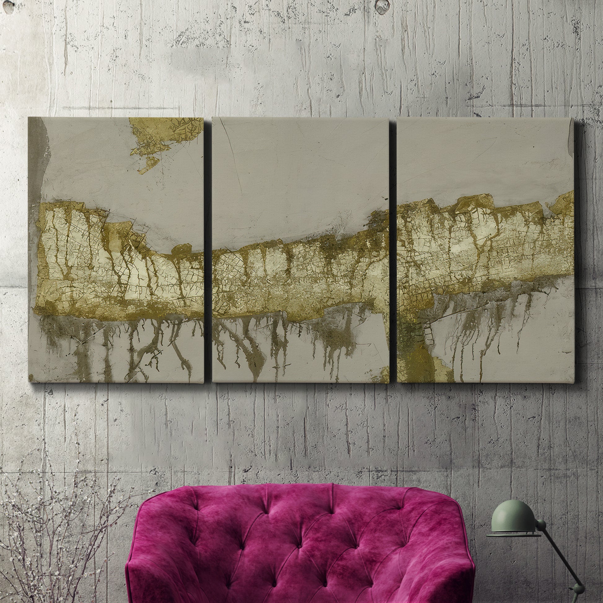 Three-panel canvas wall art featuring gold accented abstract ravine, displayed in a living room above a suede accent chair.