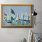 Coastal harbor watercolor painting in an ornate antique gold frame displayed in a neutral interior setting.