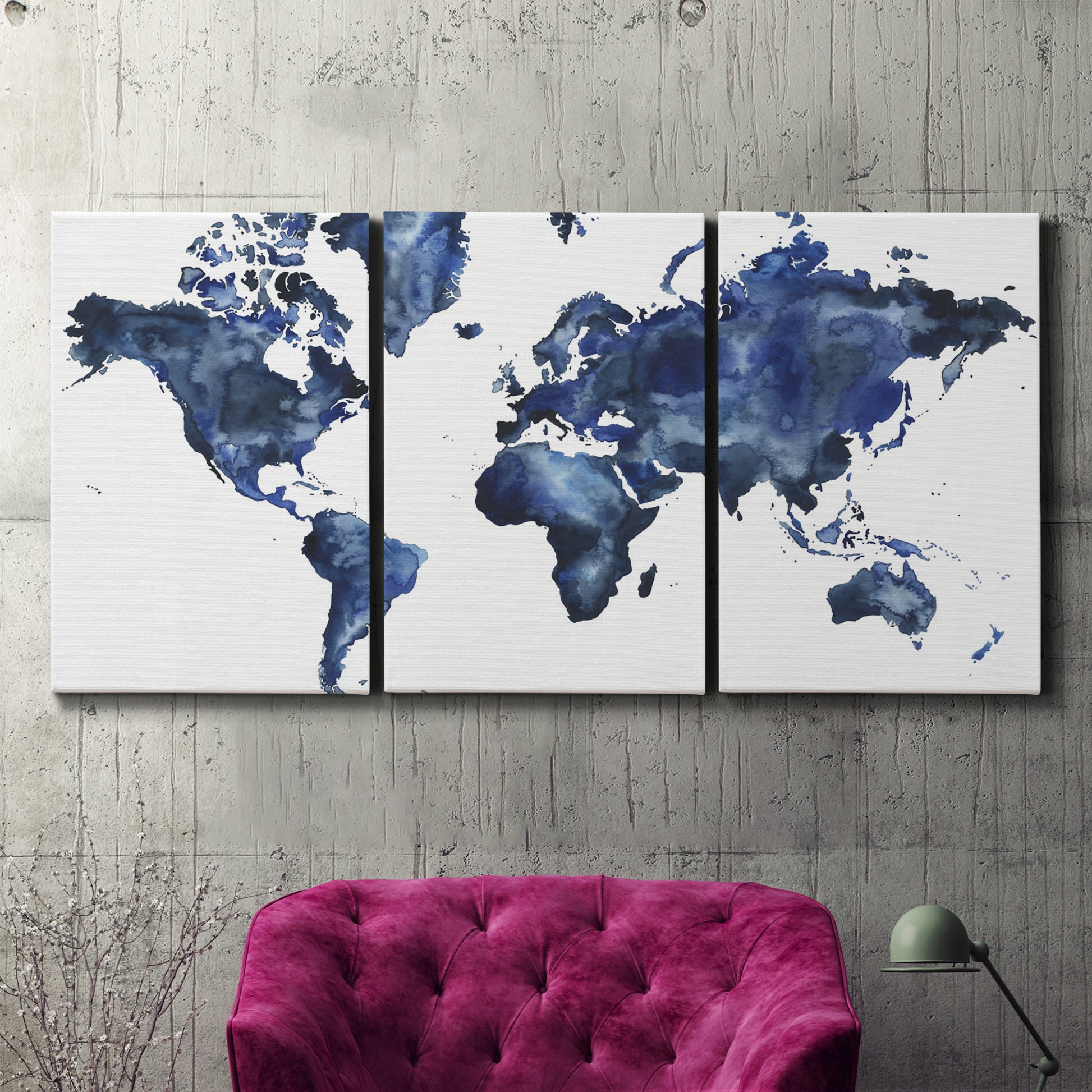 Three-panel canvas wall art featuring world map with water motif, displayed in a living room above a suede accent chair.