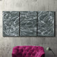 Three-panel canvas wall art featuring abstract view through window forms, displayed in a living room above a suede accent chair.