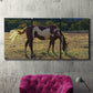Three-panel canvas wall art featuring horses standing near farmhouse, displayed in a living room above a suede accent chair.
