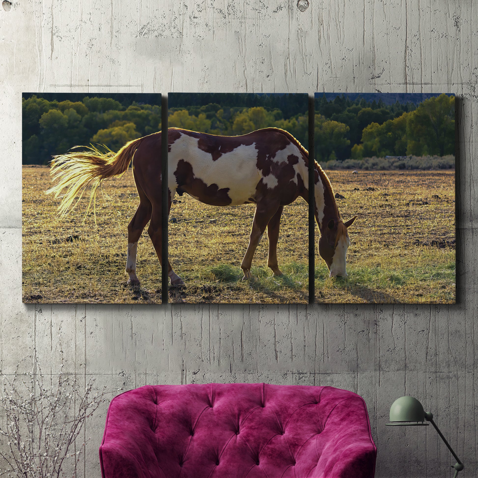 Three-panel canvas wall art featuring horses standing near farmhouse, displayed in a living room above a suede accent chair.