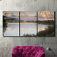 Three-panel canvas wall art featuring fog drifting over winding river, displayed in a living room above a suede accent chair.