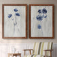 Set of two maple barnwood framed canvas prints depicting two rustic monochrome botanical paintings featuring blue wildflower stems on weathered neutral paper above a sideboard in a cozy sitting room.