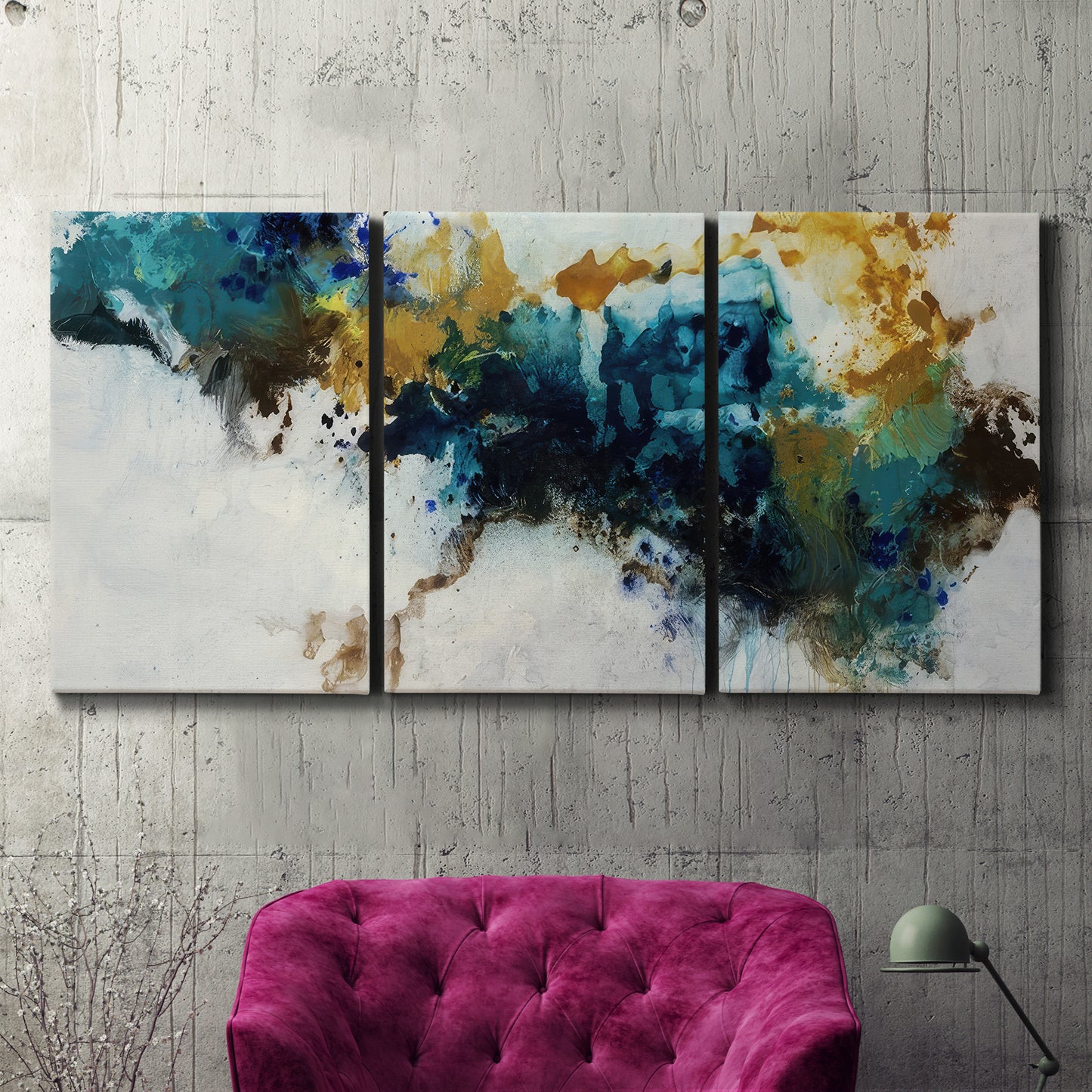 Three-panel canvas wall art featuring teal abstract paint splatter, displayed in a living room above a suede accent chair.