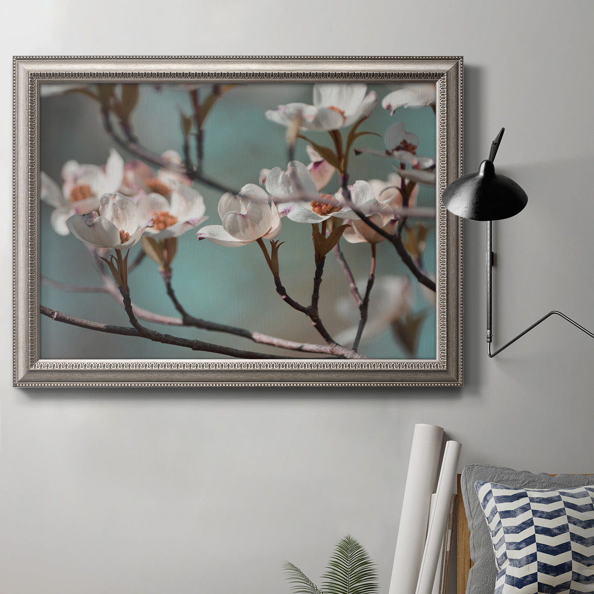 Close-up dogwood blossom photography in an ornate vintage silver frame displayed in a neutral interior setting.