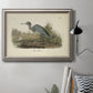 Antique blue heron bird illustration by John James Audubon in an ornate vintage silver frame displayed in a neutral interior setting.