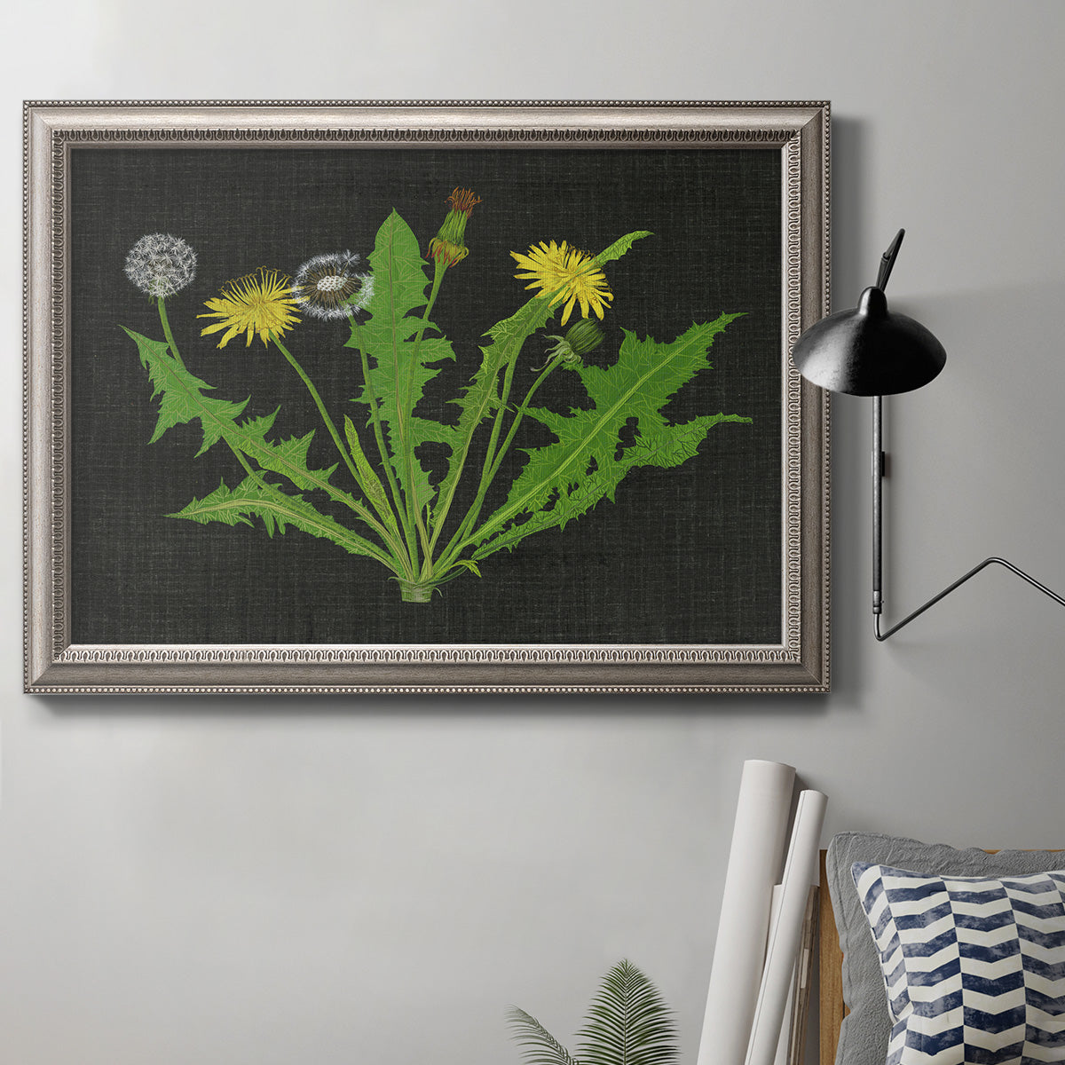 Vintage botanical dandelion flower illustration in an ornate vintage silver frame displayed in a neutral interior setting.