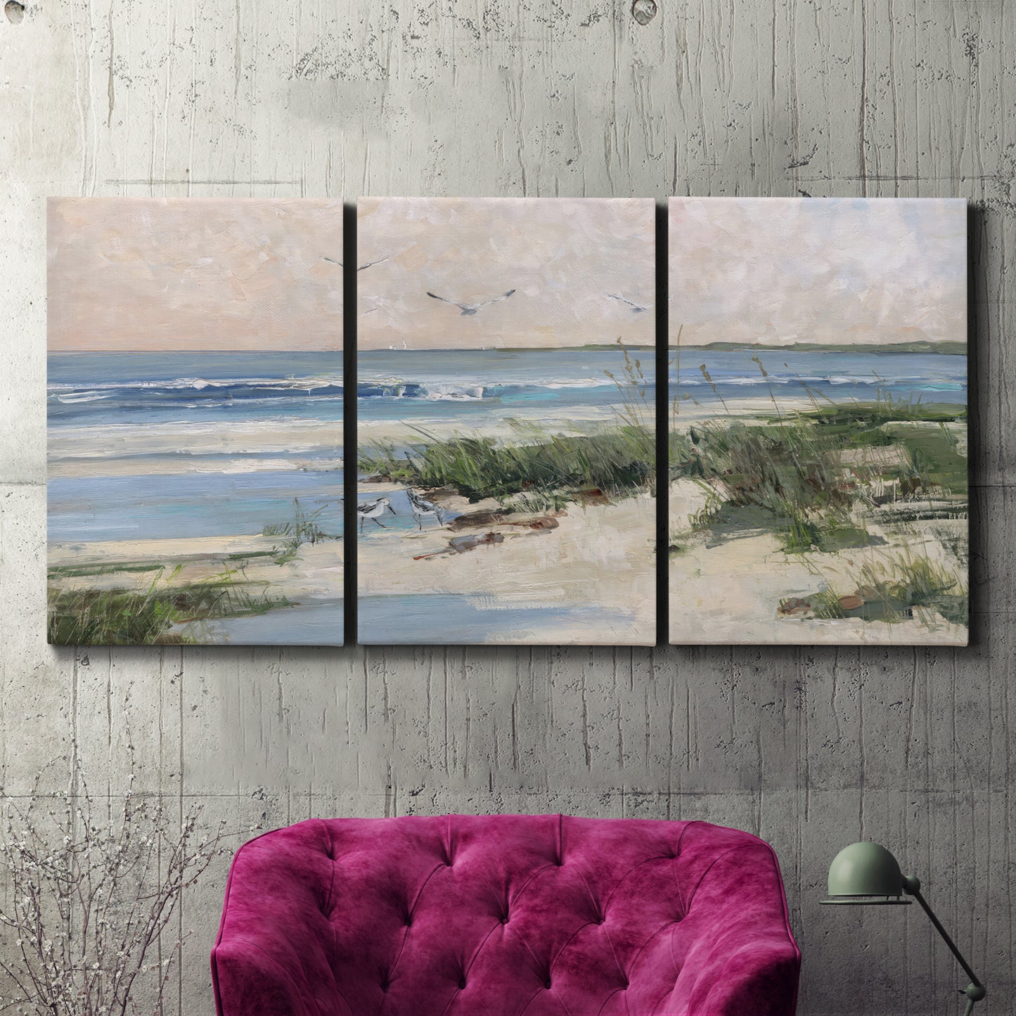Three-panel canvas wall art featuring soft morning light over calm sea, displayed in a living room above a suede accent chair.