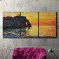Three-panel canvas wall art featuring arched coastal cliff above sea, displayed in a living room above a suede accent chair.