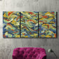 Three-panel canvas wall art featuring colorful abstract river like motion, displayed in a living room above a suede accent chair.