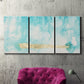 Three-panel canvas wall art featuring saturated abstract color fields, displayed in a living room above a suede accent chair.