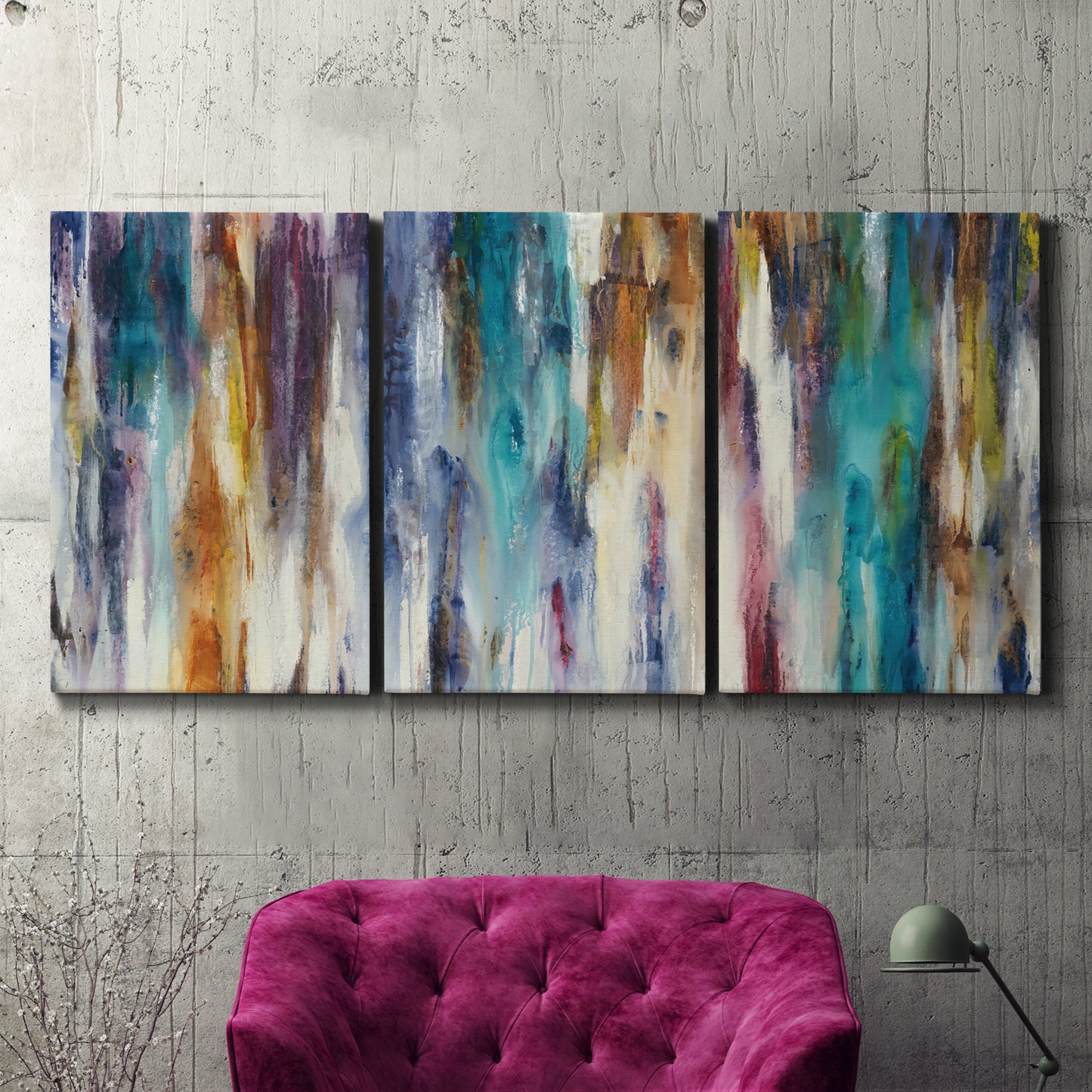 Three-panel canvas wall art featuring abstract shifting color forms, displayed in a living room above a suede accent chair.