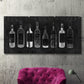 Three-panel canvas wall art featuring illustrated wine bottle cellar diagram, displayed in a living room above a suede accent chair.