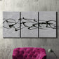 Three-panel canvas wall art featuring minimal abstract frequency lines, displayed in a living room above a suede accent chair.