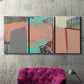Three-panel canvas wall art featuring layered mid century abstract pathways, displayed in a living room above a suede accent chair.