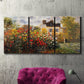Three-panel canvas wall art featuring farm buildings in rural normandy, displayed in a living room above a suede accent chair.
