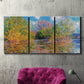 Three-panel canvas wall art featuring wide river landscape, displayed in a living room above a suede accent chair.