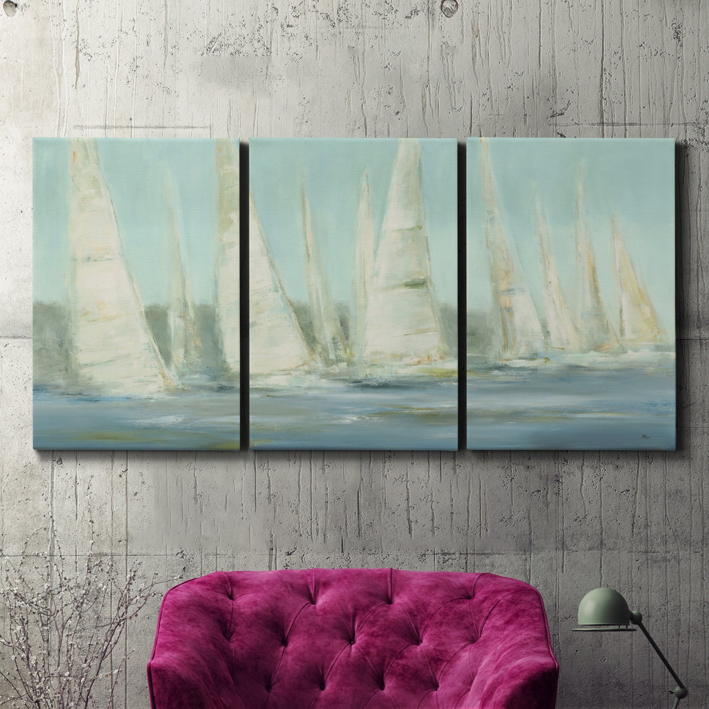 Three-panel canvas wall art featuring sailboats silhouetted at sunrise, displayed in a living room above a suede accent chair.