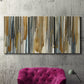 Three-panel canvas wall art featuring abstract vertical illusion pattern, displayed in a living room above a suede accent chair.