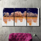 Three-panel canvas wall art featuring panoramic treeline landscape photograph, displayed in a living room above a suede accent chair.