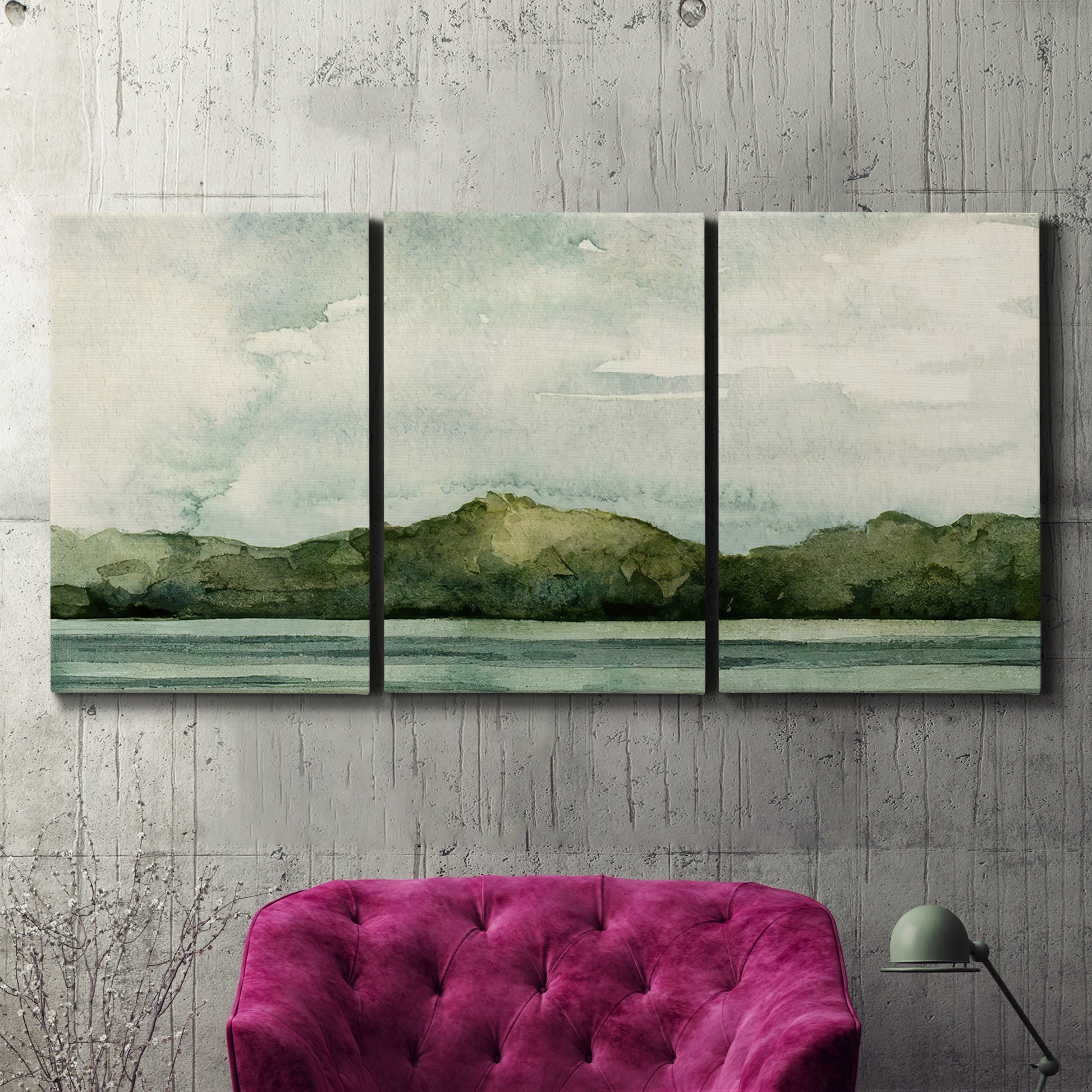 Three-panel canvas wall art featuring riverbank watercolor landscape, displayed in a living room above a suede accent chair.