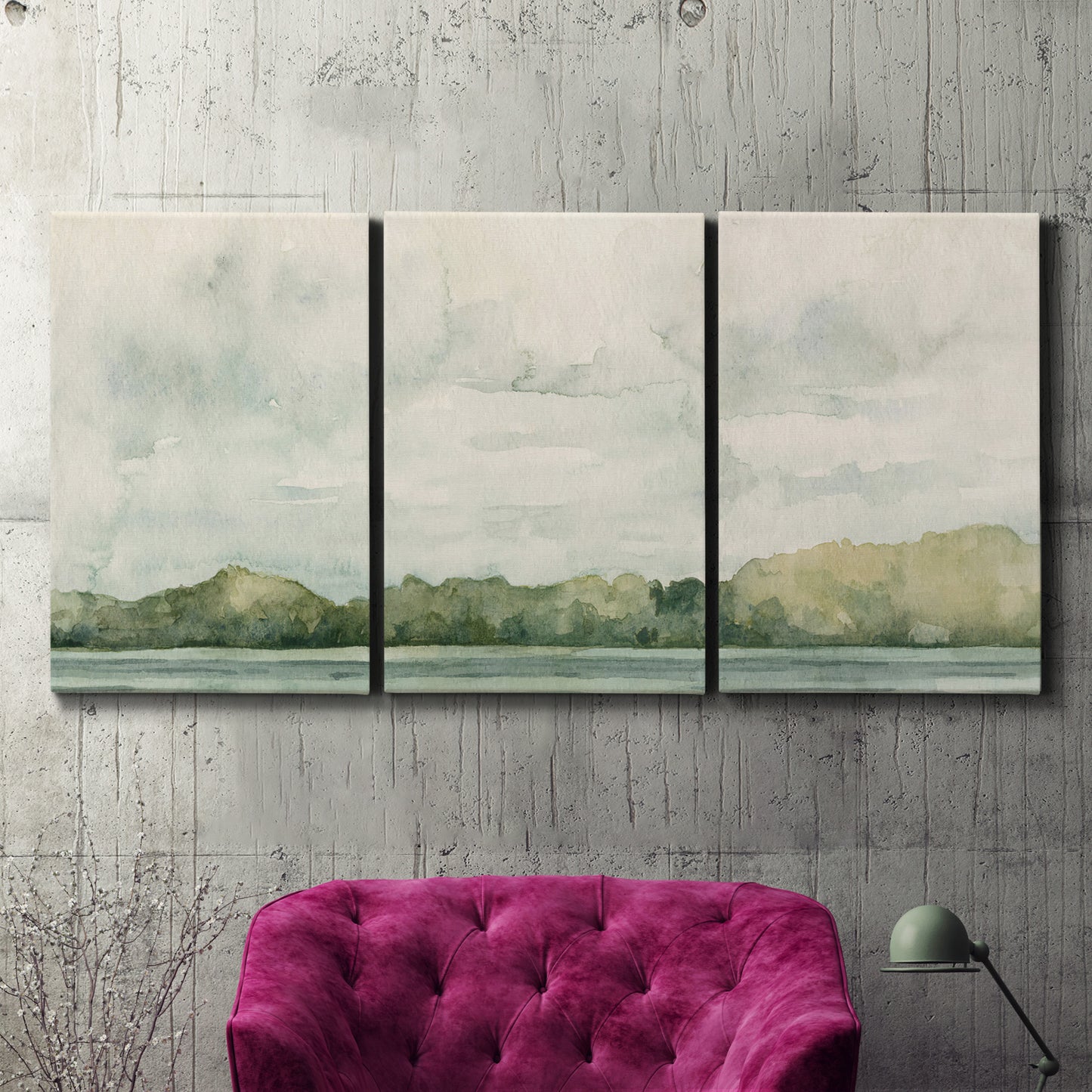 Three-panel canvas wall art featuring riverbank landscape with trees, displayed in a living room above a suede accent chair.
