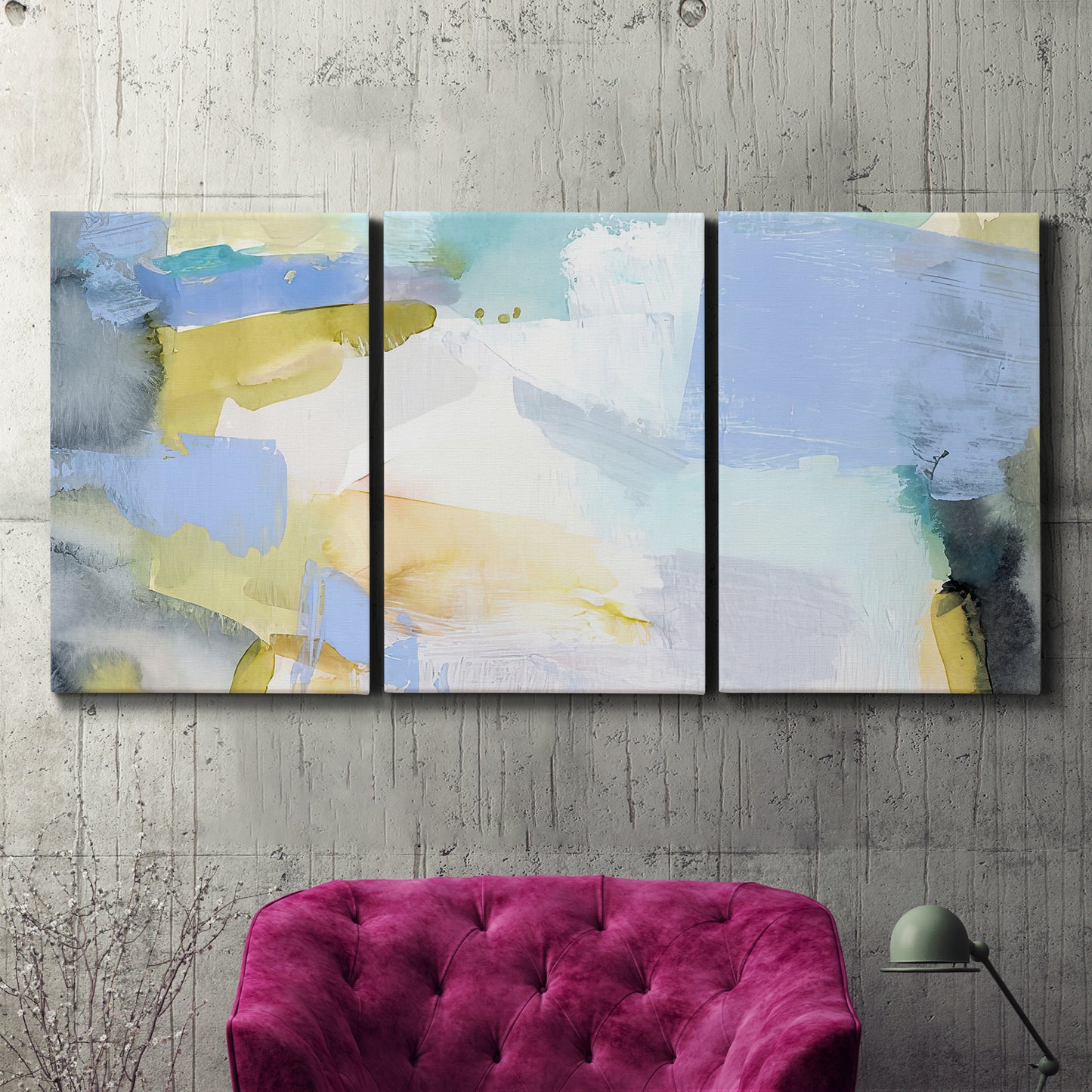 Three-panel canvas wall art featuring soft abstract spring watercolor tones, displayed in a living room above a suede accent chair.