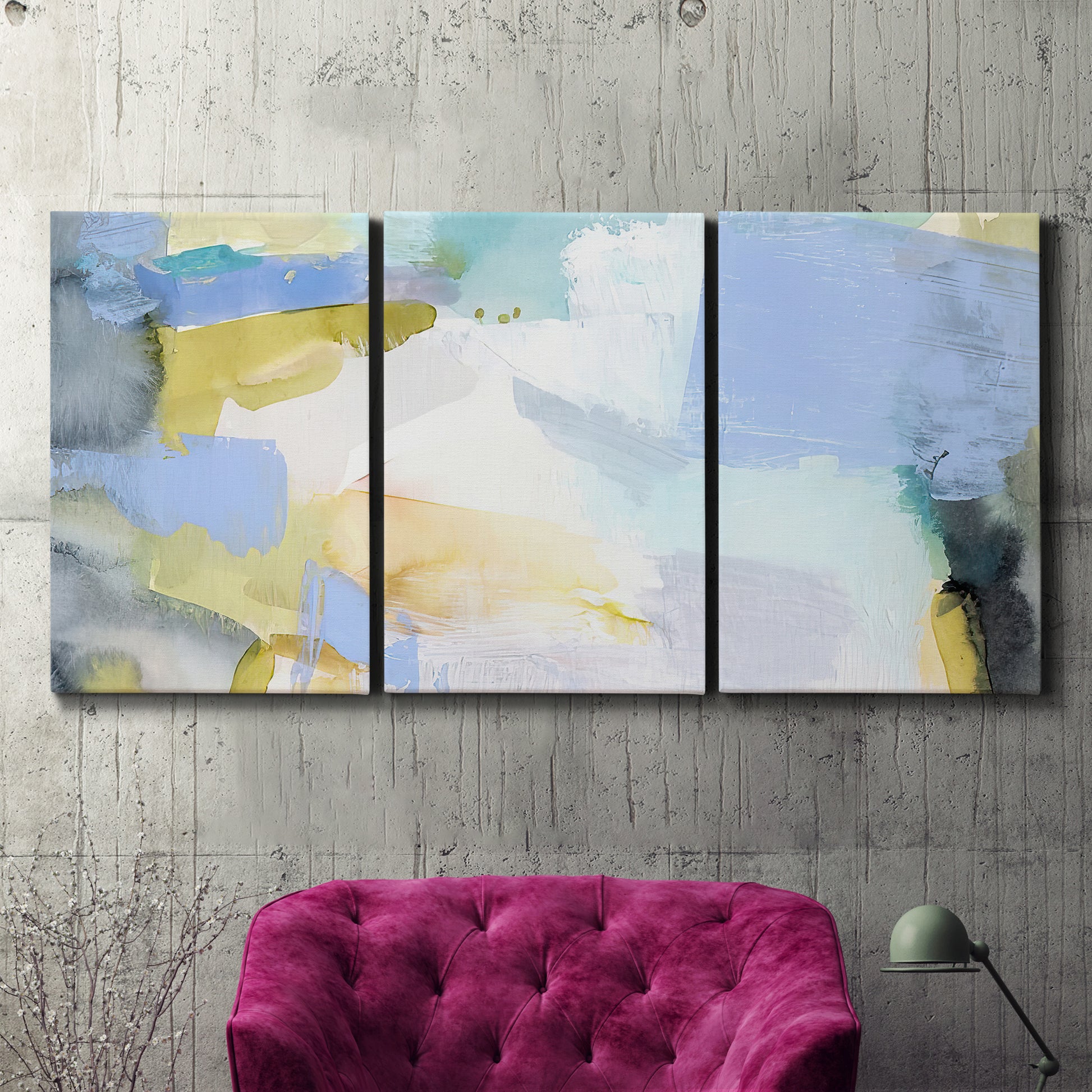 Three-panel canvas wall art featuring soft abstract spring watercolor tones, displayed in a living room above a suede accent chair.