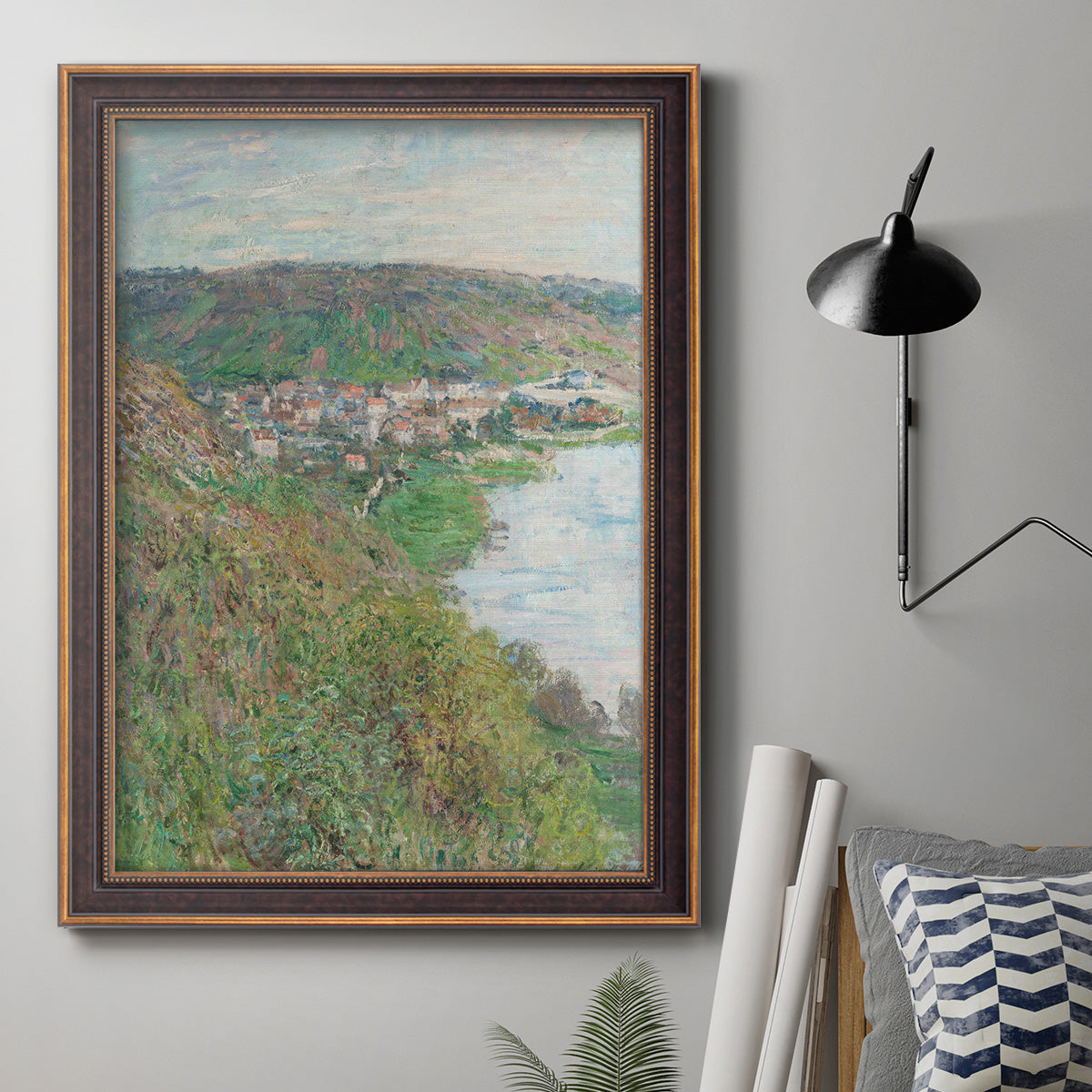 Impressionist landscape view of Vétheuil by Claude Monet in an ornate bronzed mahogany wood frame displayed in a neutral interior setting.