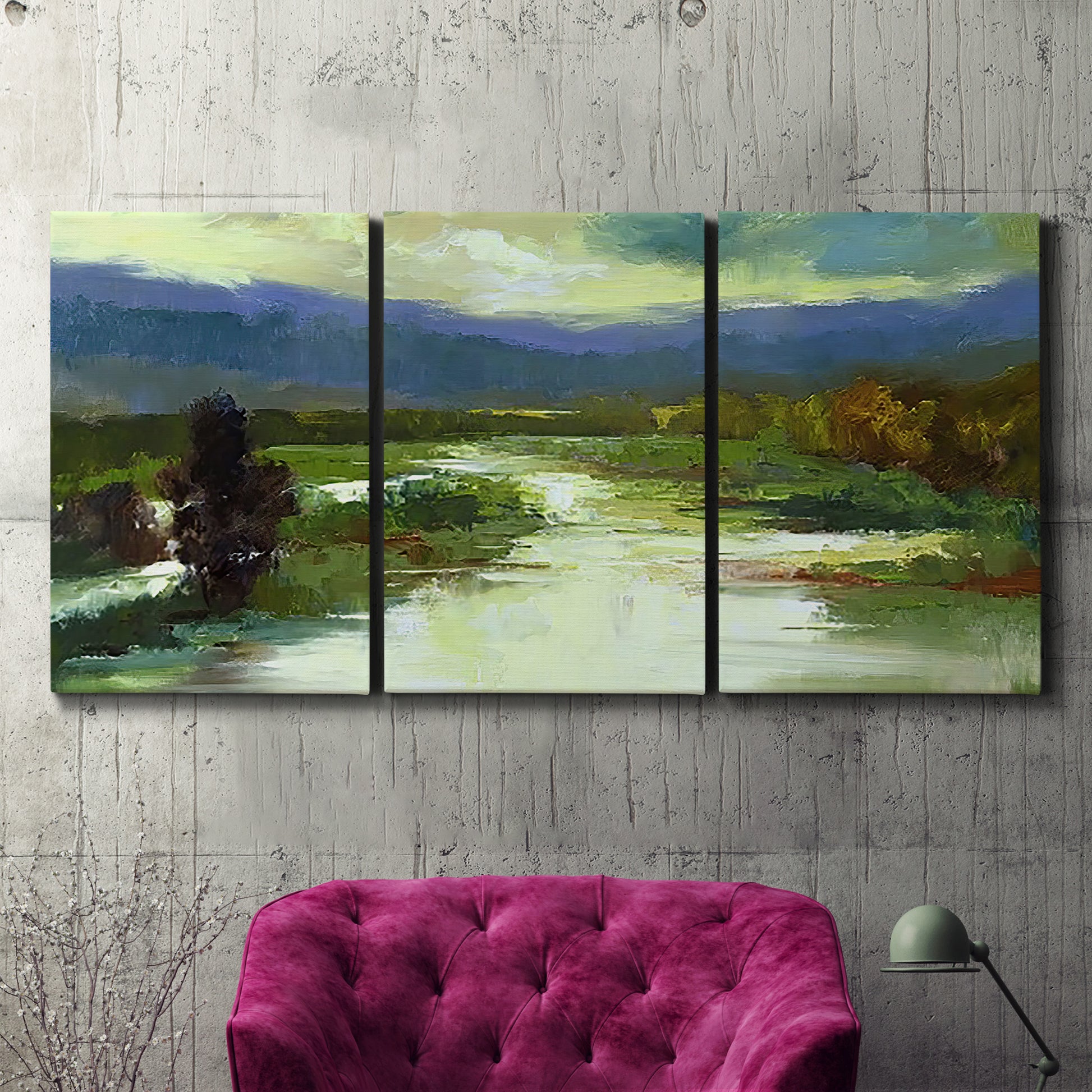 Three-panel canvas wall art featuring open meadow landscape with distant hills, displayed in a living room above a suede accent chair.