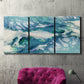 Three-panel canvas wall art featuring layered abstract marble textures, displayed in a living room above a suede accent chair.