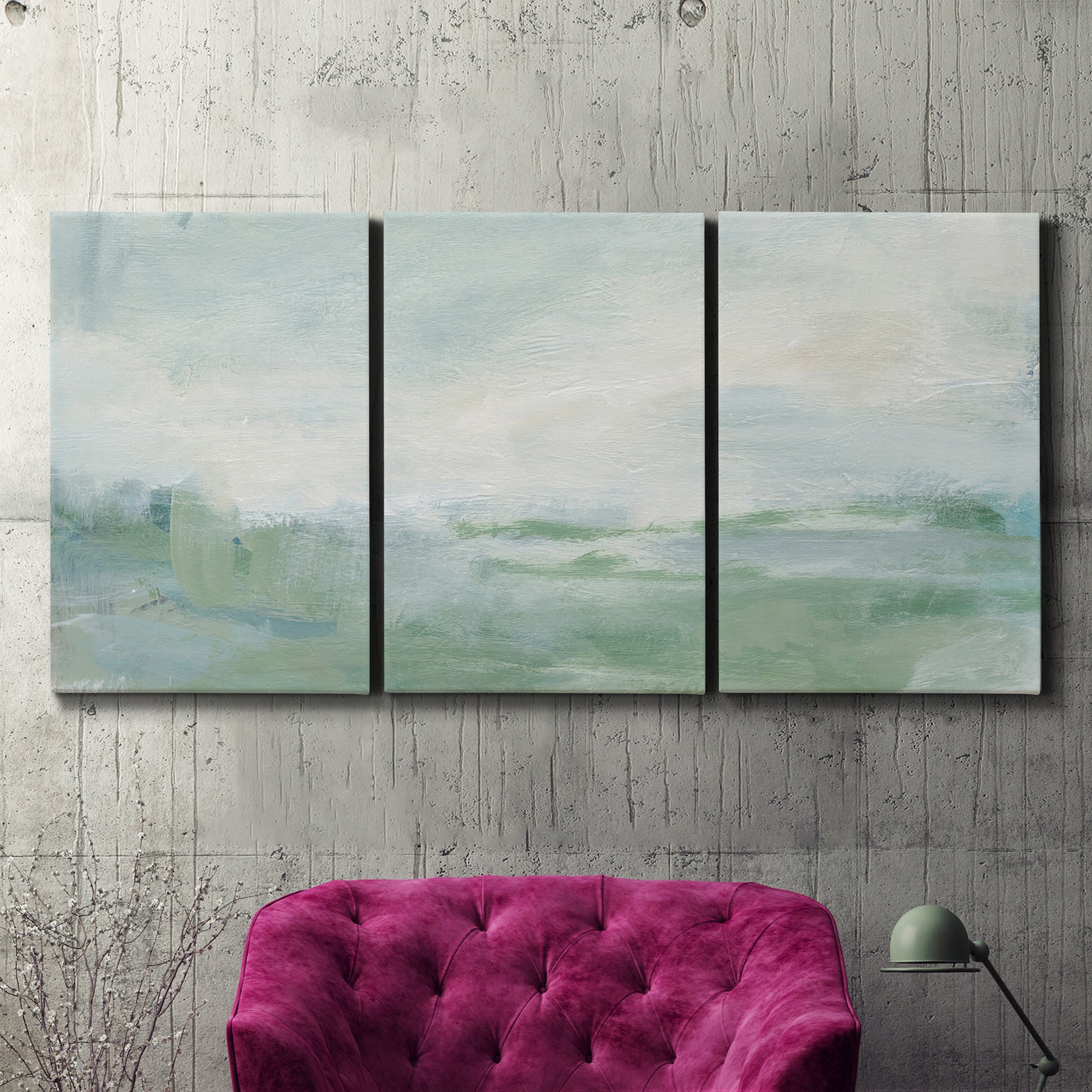 Three-panel canvas wall art featuring soft abstract coastal tones, displayed in a living room above a suede accent chair.