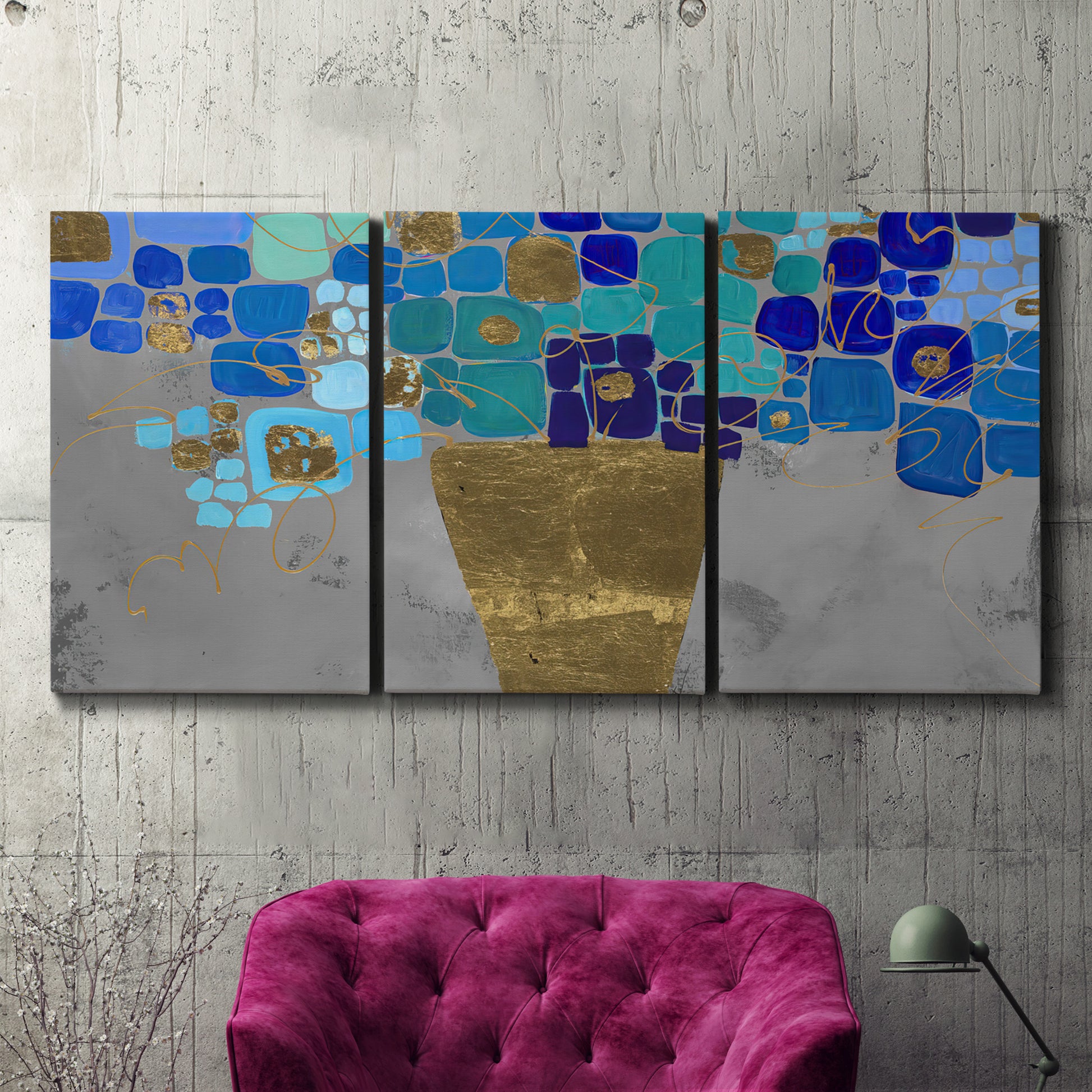 Three-panel canvas wall art featuring blue floral abstract botanical expression, displayed in a living room above a suede accent chair.
