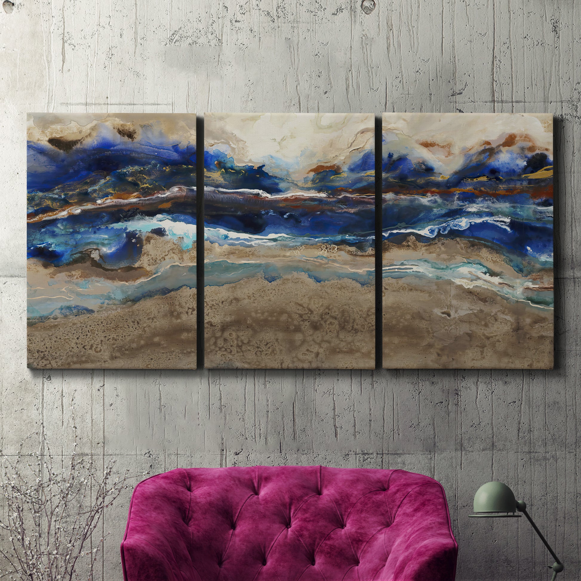 Three-panel canvas wall art featuring abstract coastal jewel toned composition, displayed in a living room above a suede accent chair.