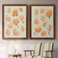 Set of two maple barnwood framed canvas prints depicting two airy watercolor floral paintings featuring loose peach-orange tulip-like blossoms above a sideboard in a cozy sitting room.