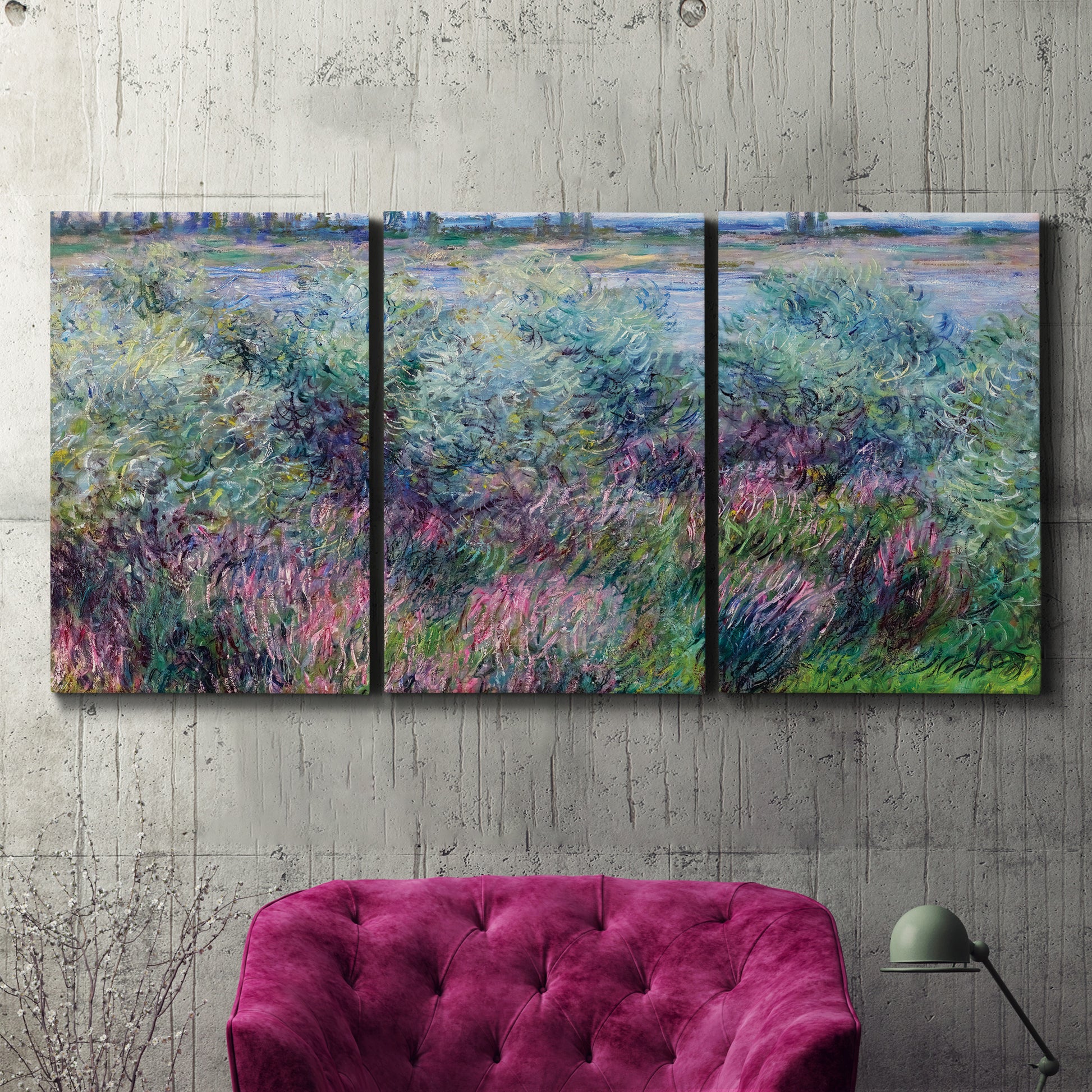 Three-panel canvas wall art featuring flowered riverbank with trees, displayed in a living room above a suede accent chair.