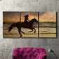 Three-panel canvas wall art featuring running horse along beach photograph, displayed in a living room above a suede accent chair.