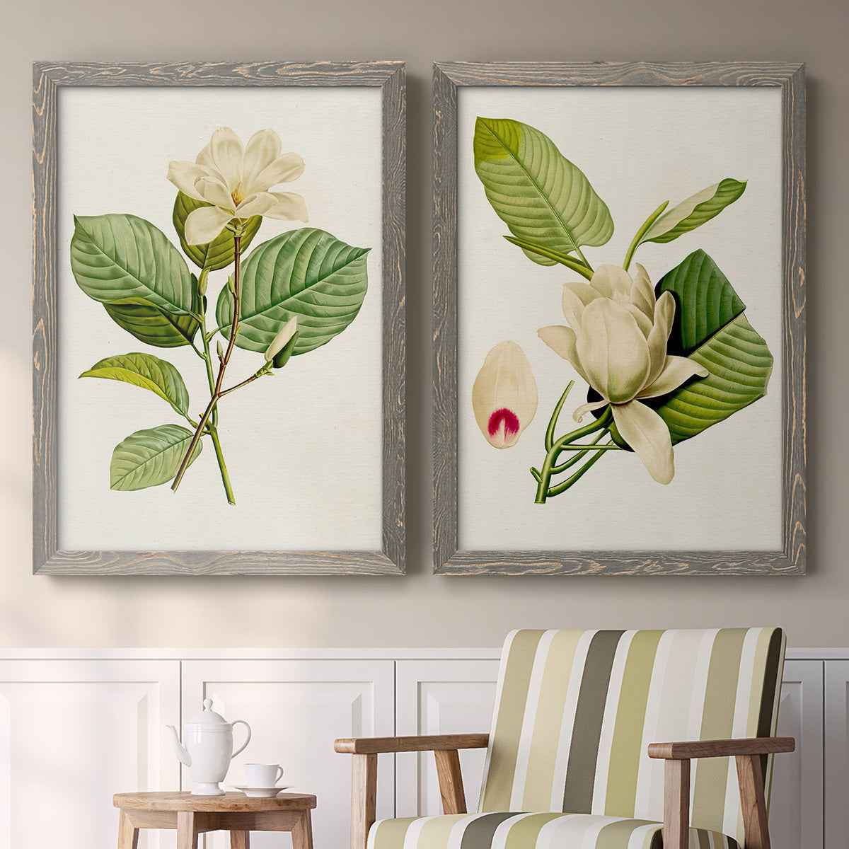 Set of two gray barnwood framed canvas prints depicting two traditional botanical paintings featuring white magnolia blossoms and glossy green leaves above a sideboard in a cozy sitting room.