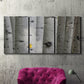 Three-panel canvas wall art featuring close up tree bark texture photograph, displayed in a living room above a suede accent chair.