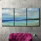 Three-panel canvas wall art featuring narrow island inlet waters, displayed in a living room above a suede accent chair.