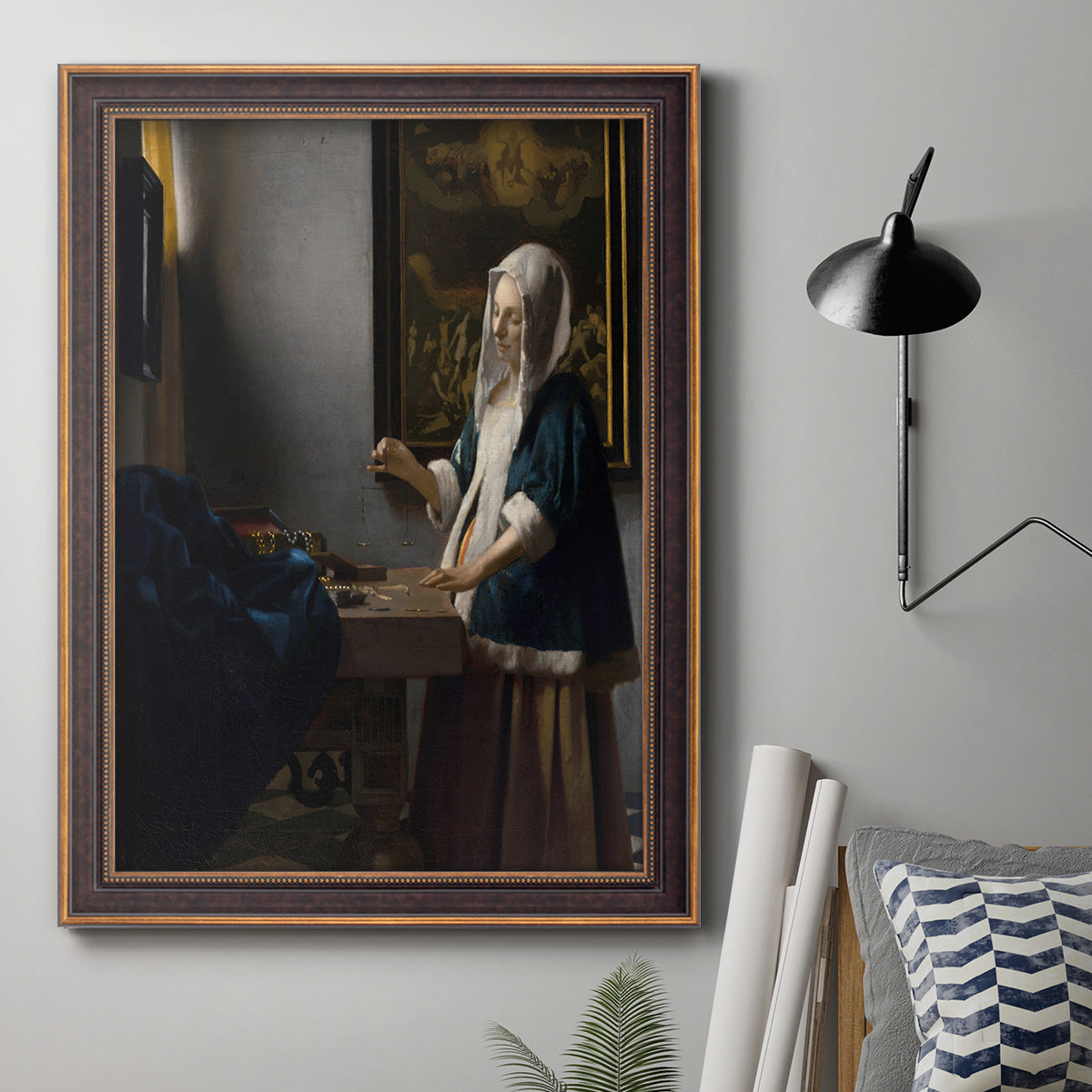 Quiet interior genre scene of a woman with scales by Johannes Vermeer in an ornate bronzed mahogany wood frame displayed in a neutral interior setting.