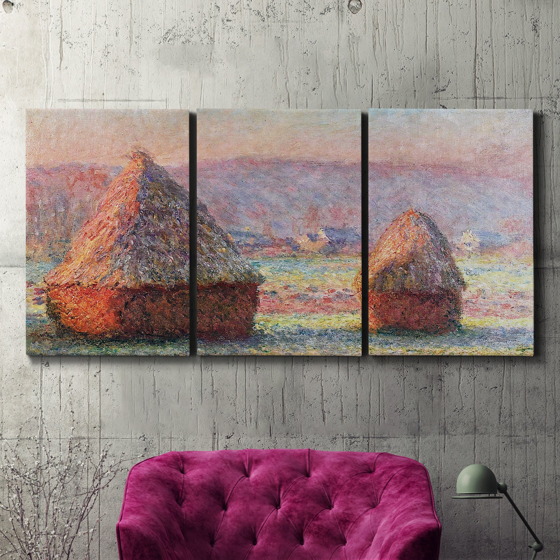 Three-panel canvas wall art featuring winter grainstacks glowing at sunset, displayed in a living room above a suede accent chair.