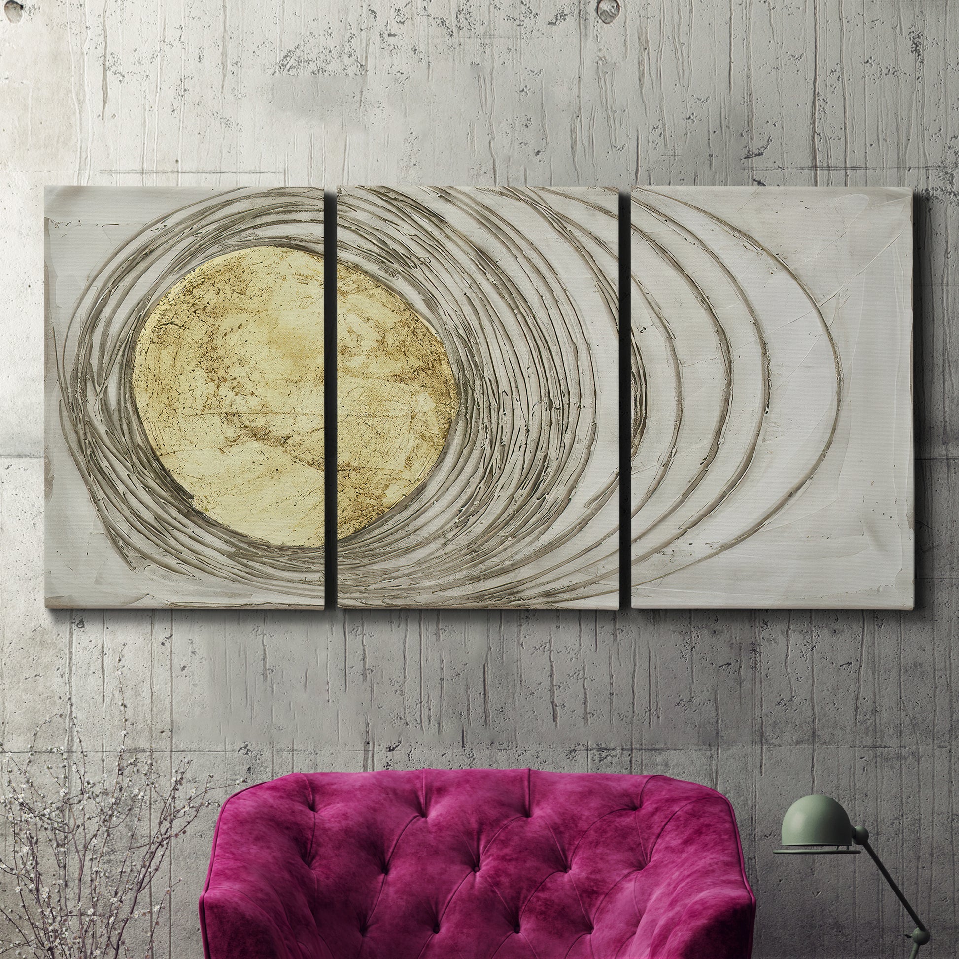 Three-panel canvas wall art featuring circular abstract energy forms, displayed in a living room above a suede accent chair.