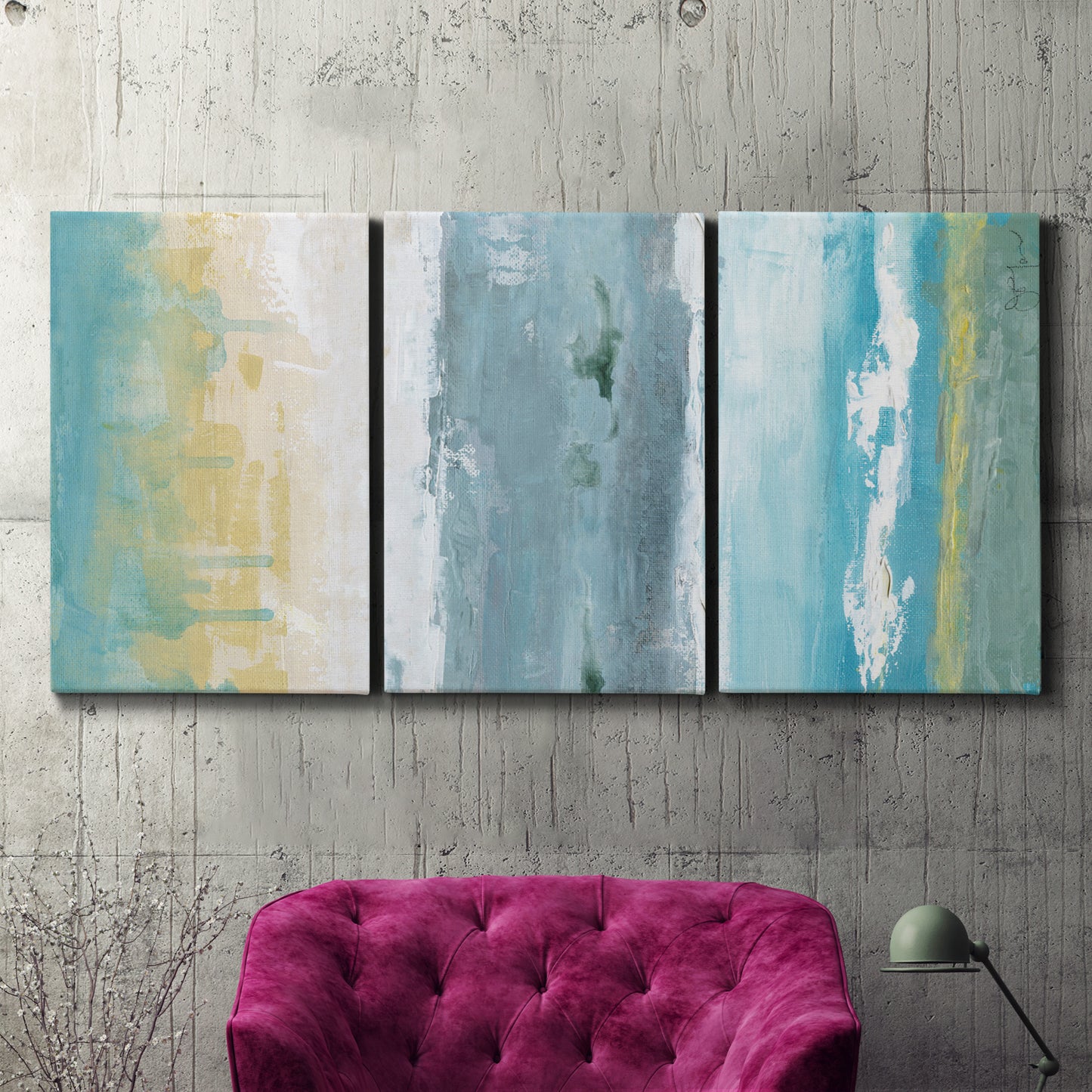 Three-panel canvas wall art featuring abstract coastal shoreline textures, displayed in a living room above a suede accent chair.