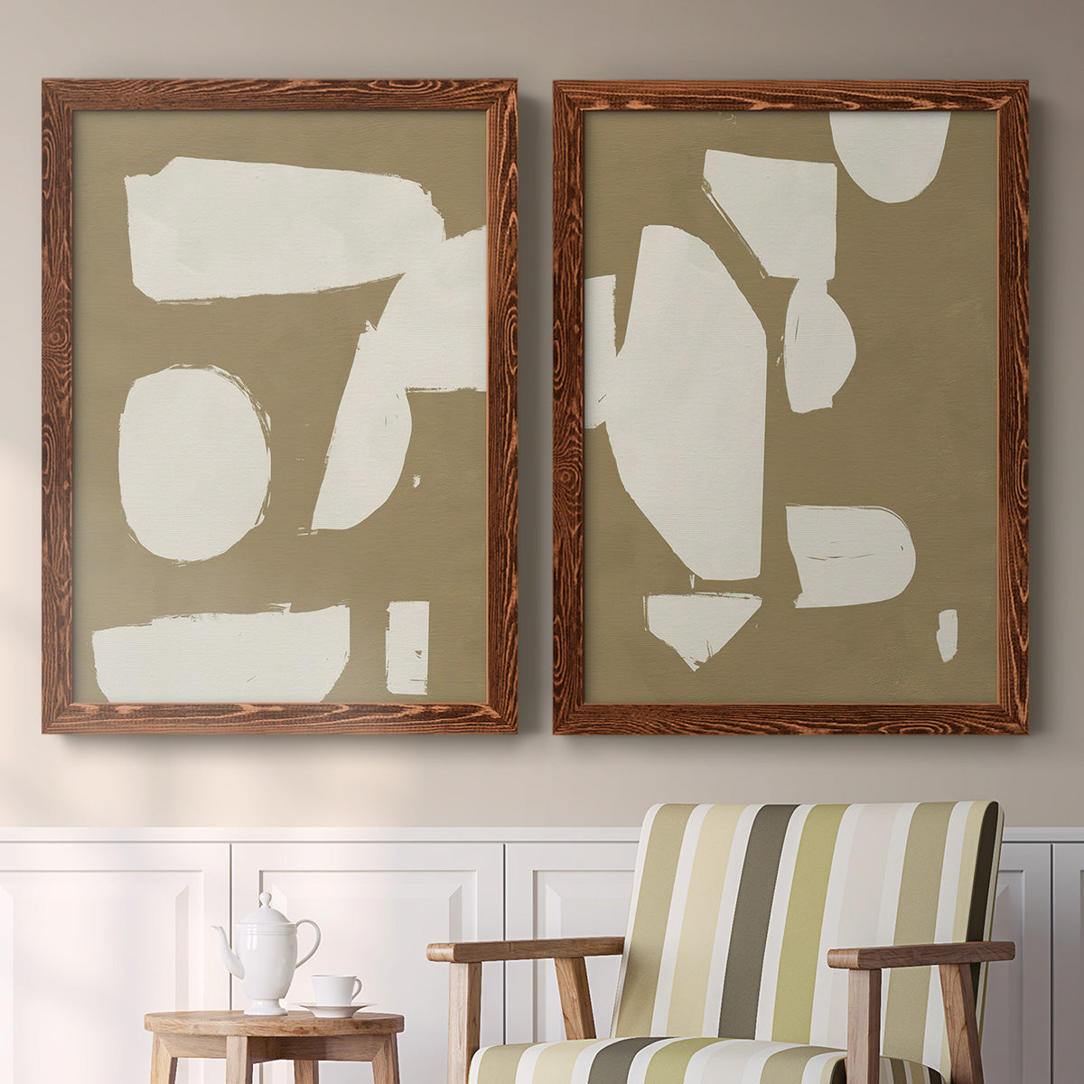 Set of two maple barnwood framed canvas prints depicting two bold minimalist shape abstracts featuring irregular white cutout-like shapes on taupe grounds above a sideboard in a cozy sitting room.