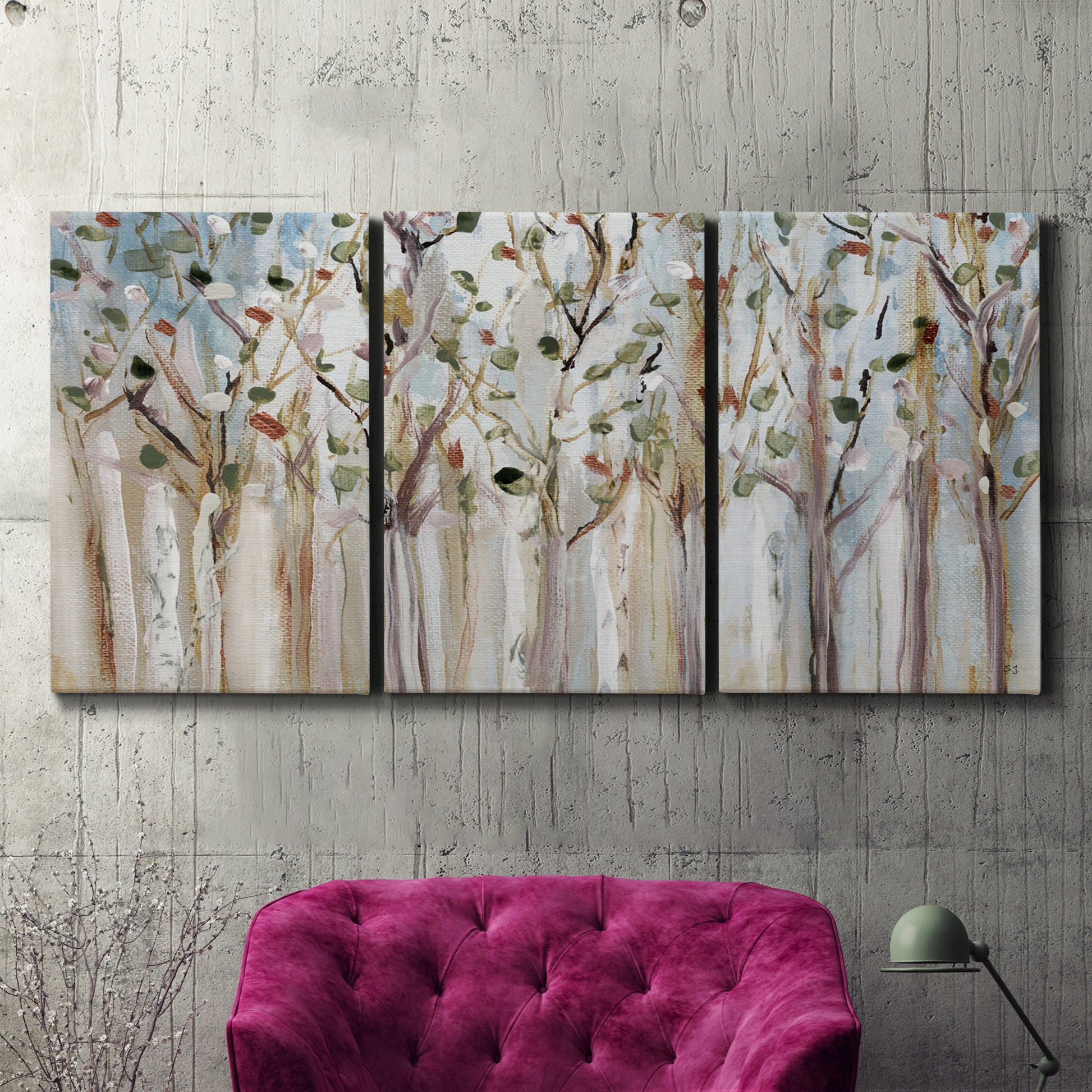 Three-panel canvas wall art featuring bare birch trees in winter forest, displayed in a living room above a suede accent chair.